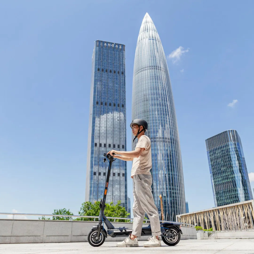 Electric Scooter Kingsong N12 Pro, sleek design with a rider in urban setting among modern skyscrapers.