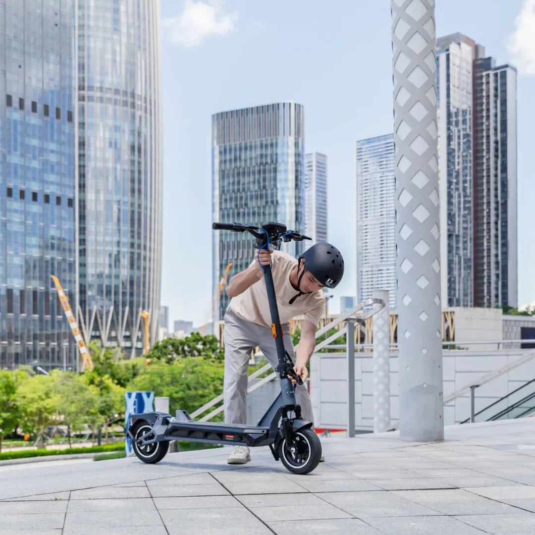 Electric scooter KingSong N12 Pro – person folding scooter in urban setting
