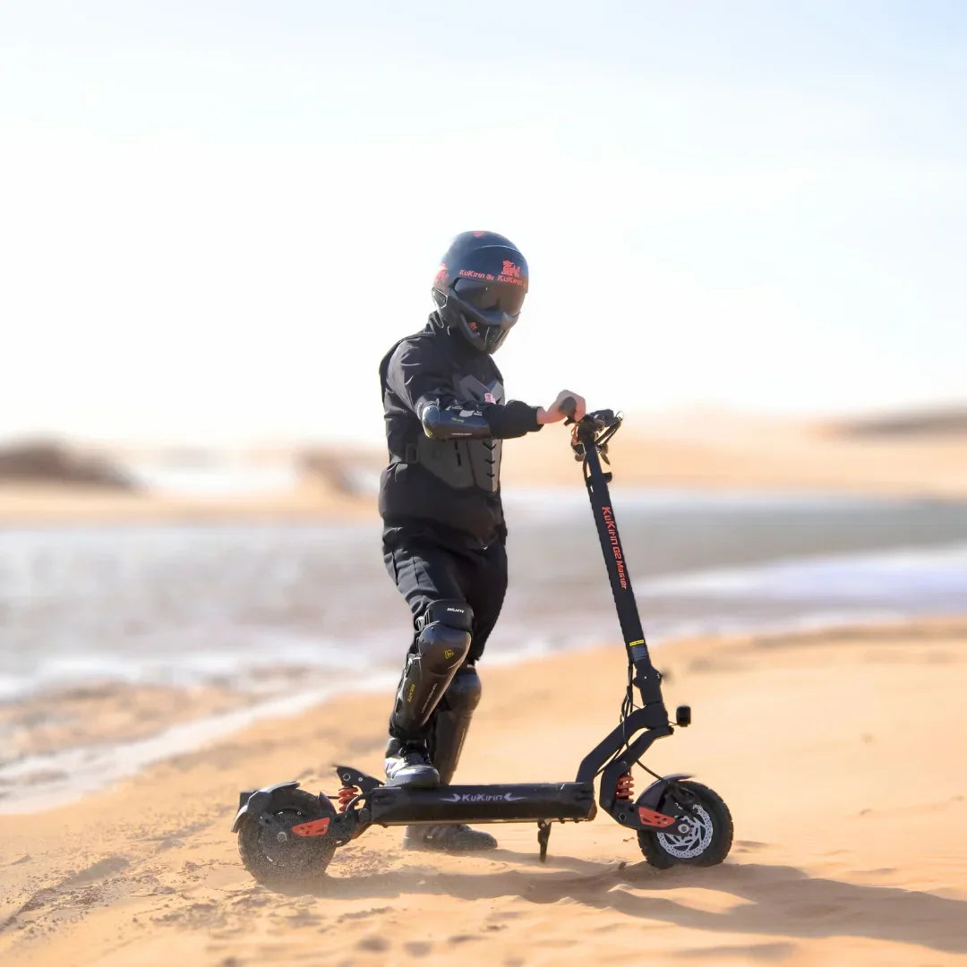 Electric scooter KuKirin G2 Master 2025 – rider standing with scooter in sand