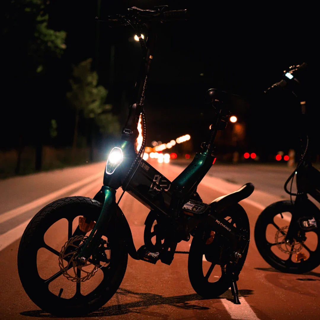 Electric bicycle MS Energy UrbanFold i6 – front three-quarter view, headlight on, at night