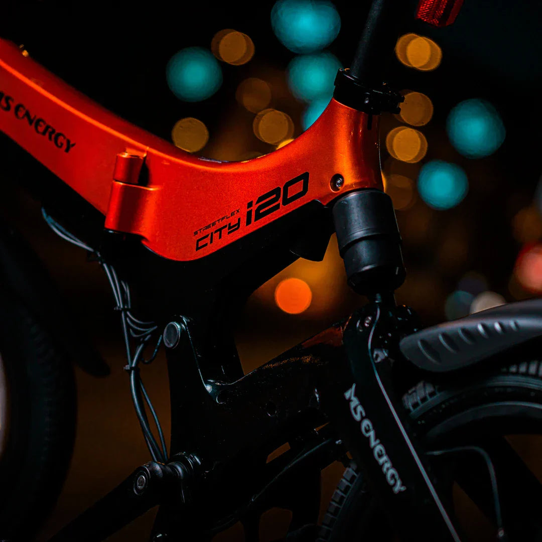 Electric bicycle MS Energy StreetFlex i20 – frame detail, orange colour, night bokeh