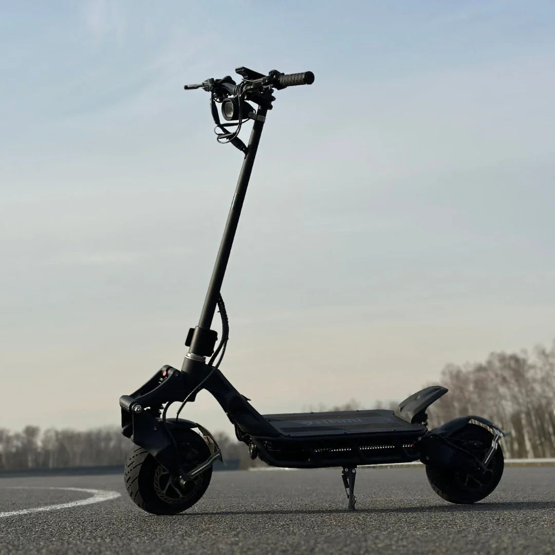 An electric scooter Nami Blast 2 Max is parked on a smooth asphalt surface under a clear sky