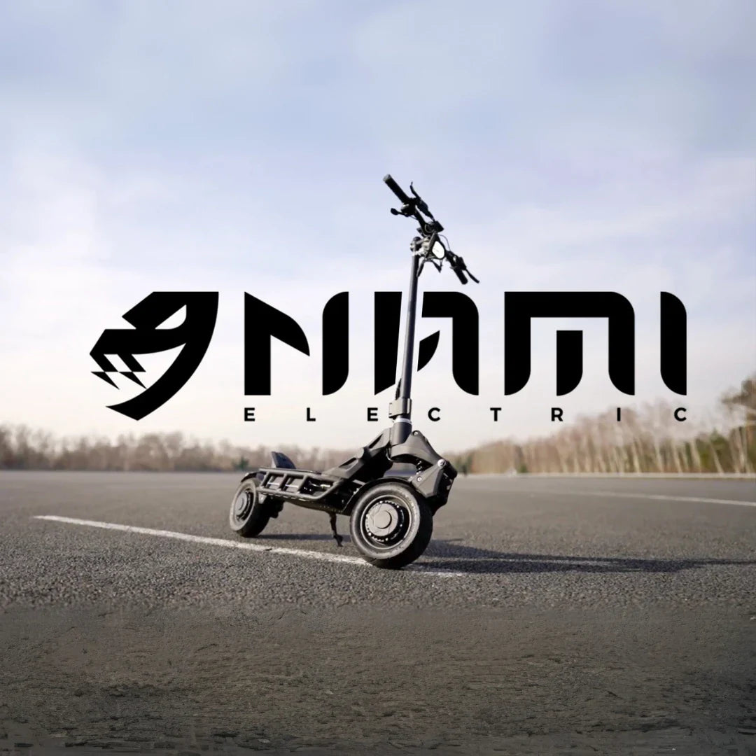 An electric scooter Nami Blast 2 Max is parked on an empty road with a logo in the background