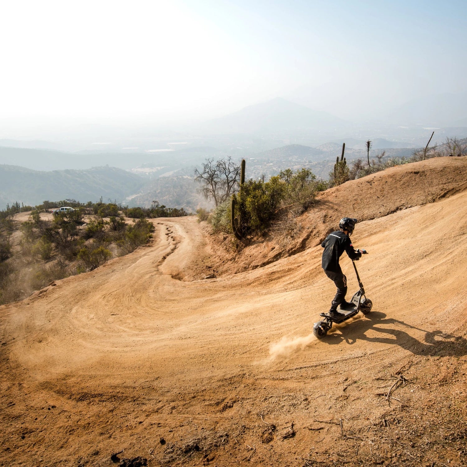 Electric Scooter Nami Burn E 3 Max, showcasing off-road capabilities on a winding dirt path.