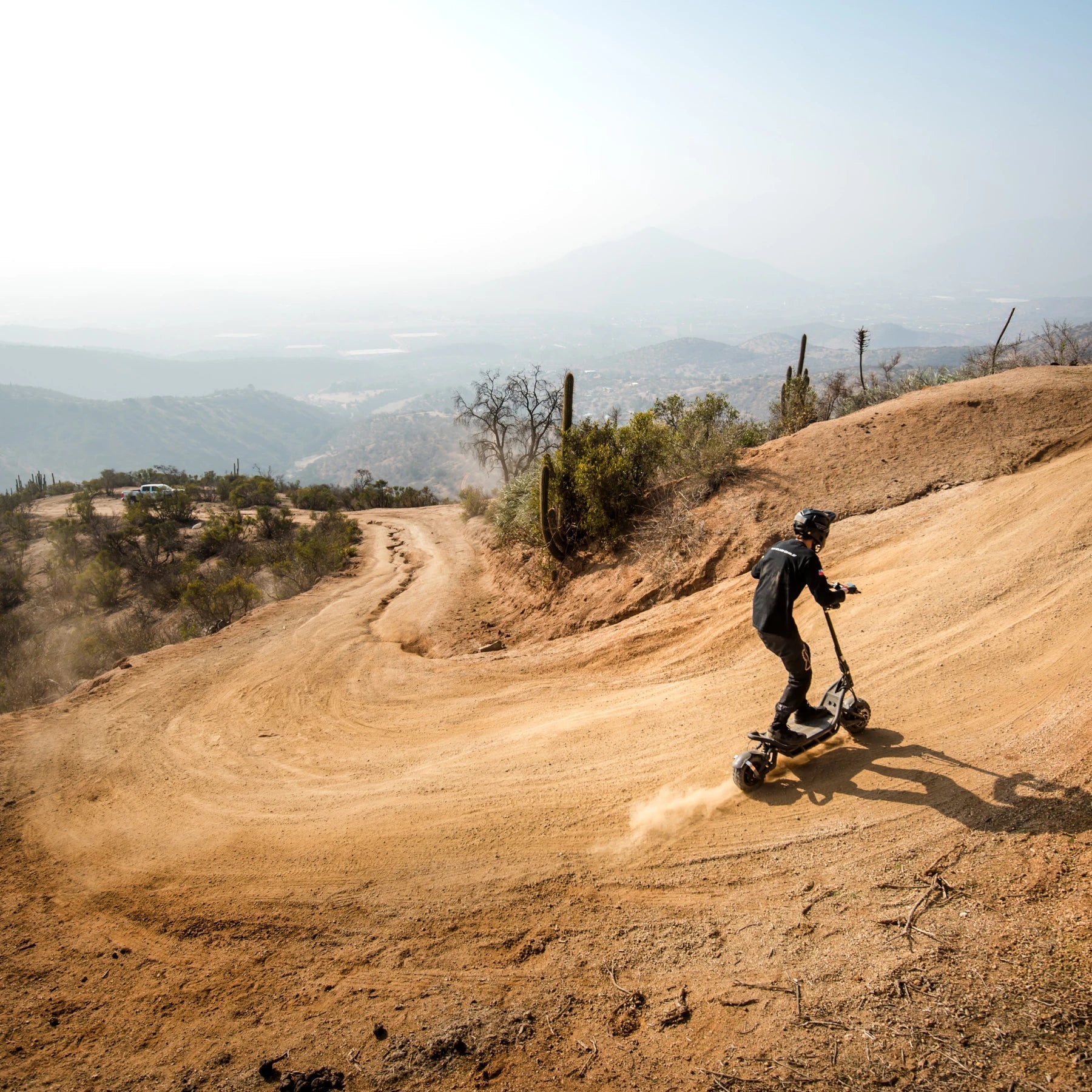 Electric Scooter Nami Burn E 3 Max, showcasing off-road capabilities on a winding dirt path.