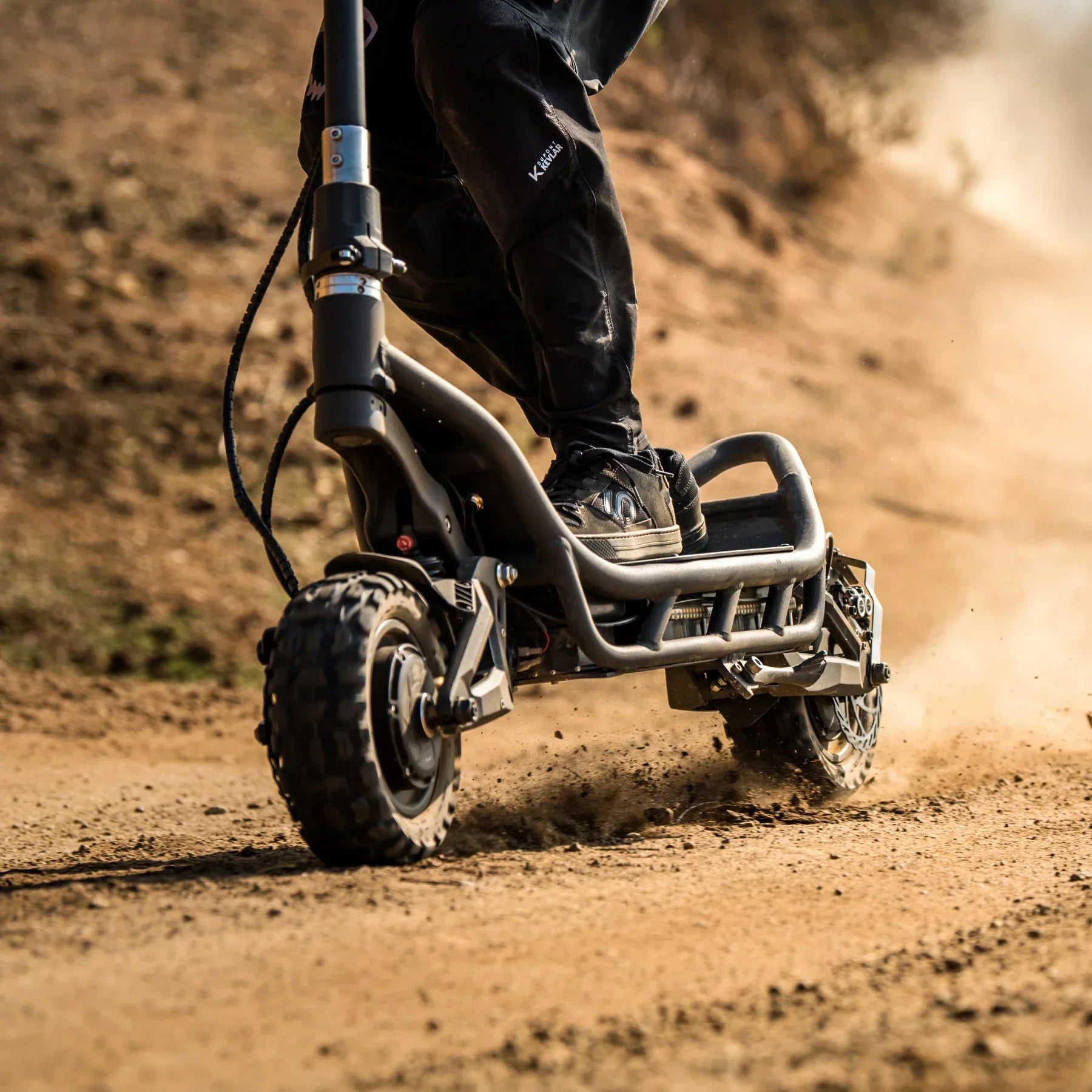 Electric Scooter Nami Burn E 3 Max, rugged design, off-road tires, dust kicking up, ideal for adventure rides.