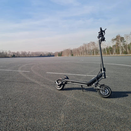 Electric Scooter Nami Klima Max, sleek black design, positioned on a vast empty tarmac, ready to ride.