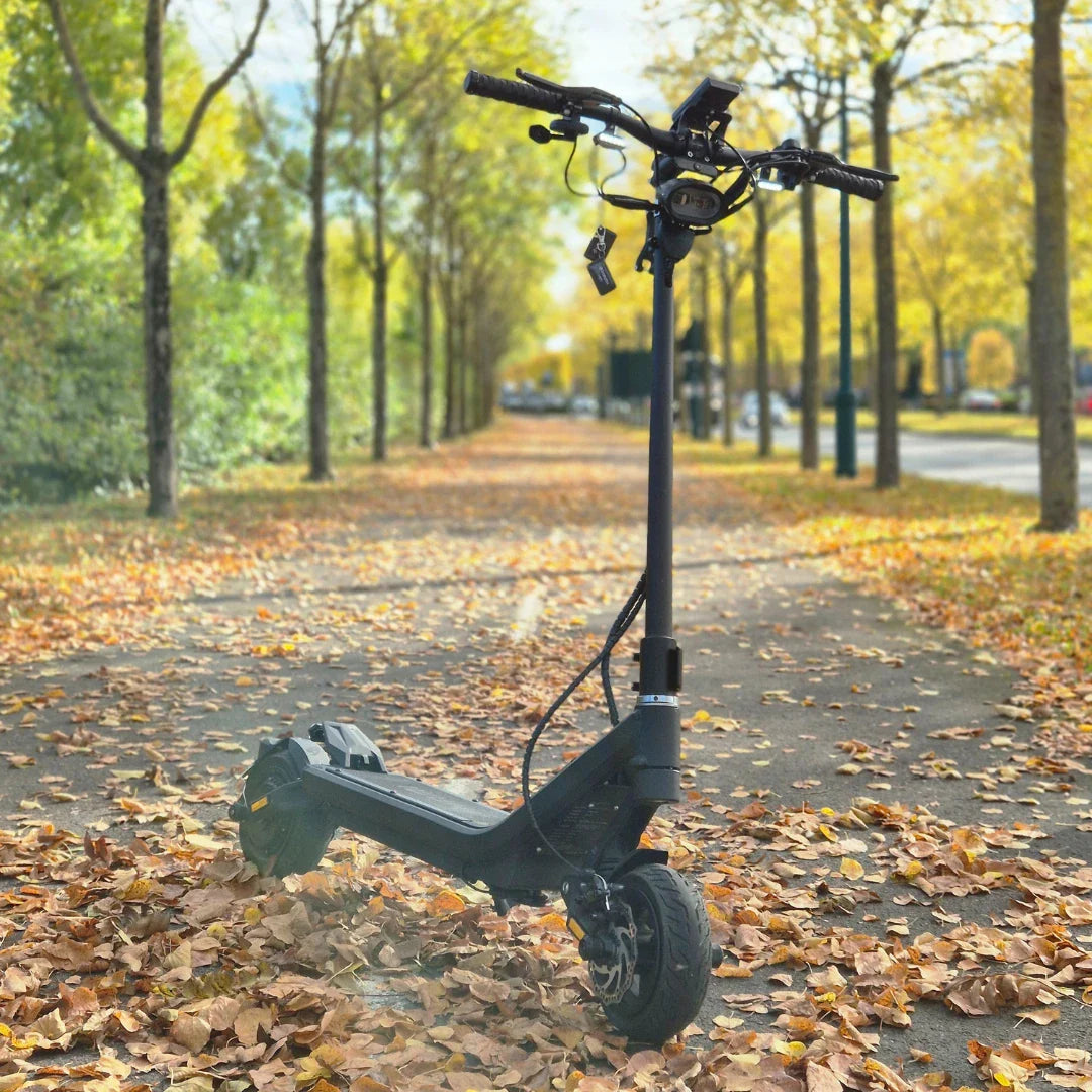 Electric Scooter Nami Superstellar features a sleek design, perfect for riding through autumn roads covered in leaves.