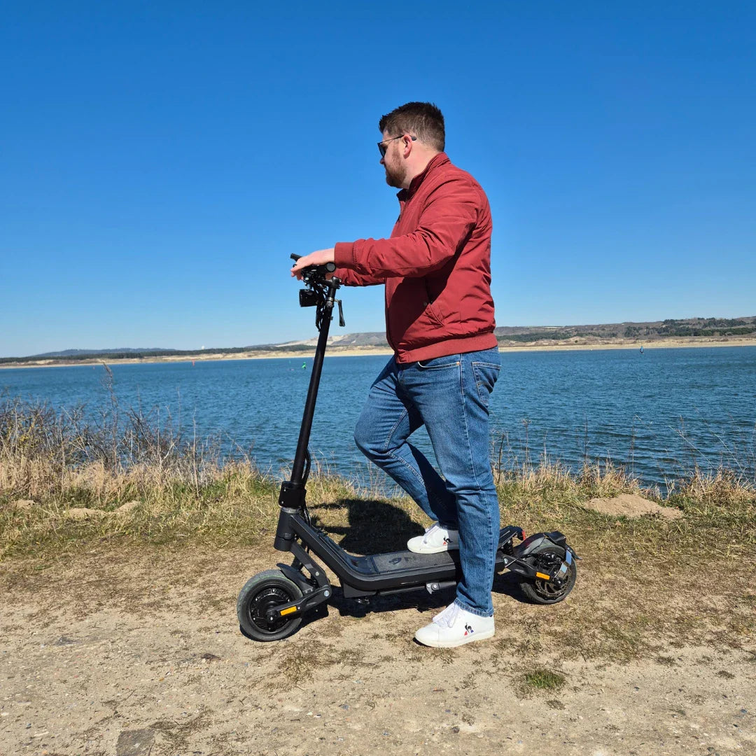 Electric Scooter Nami Superstellar, sleek electric scooter parked by a scenic water view, ideal for cruising.