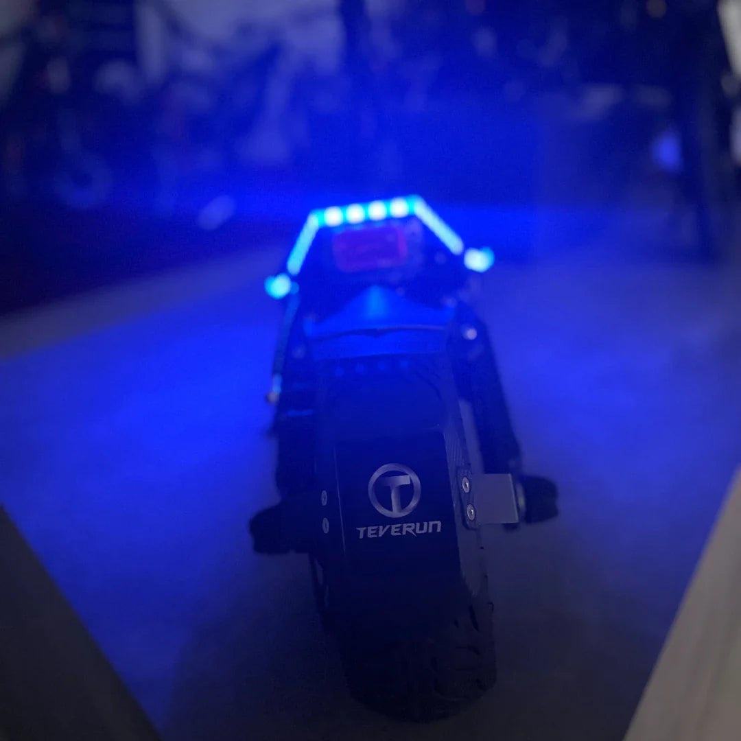 Electric Scooter Teverun Fighter Mini Pro 2025 features a sleek design with vibrant blue LED lights, perfect for night rides.