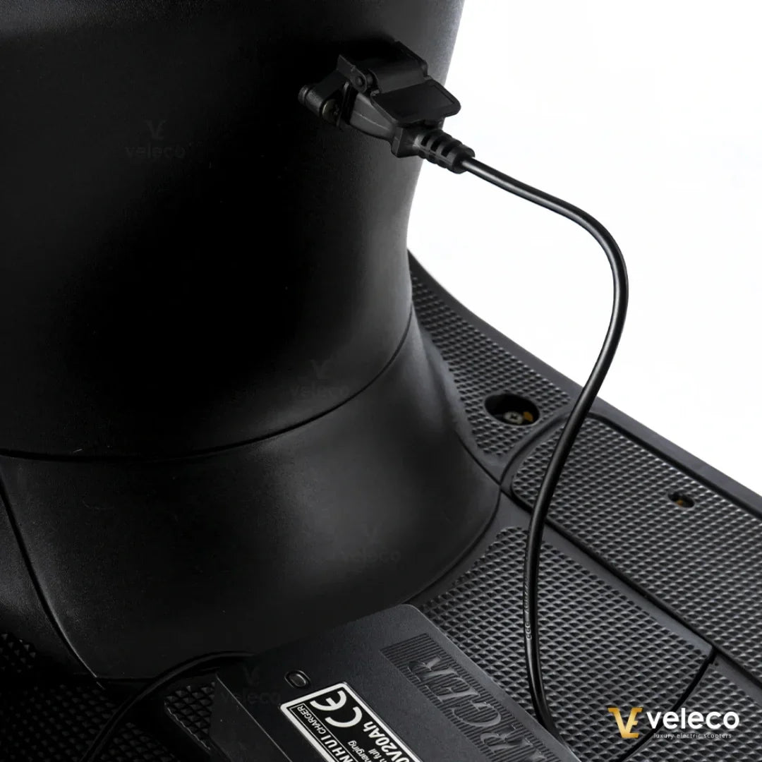 Electric Mobility Scooter Veleco Zt63 features a sleek design, showcasing a charging port connected to the battery.