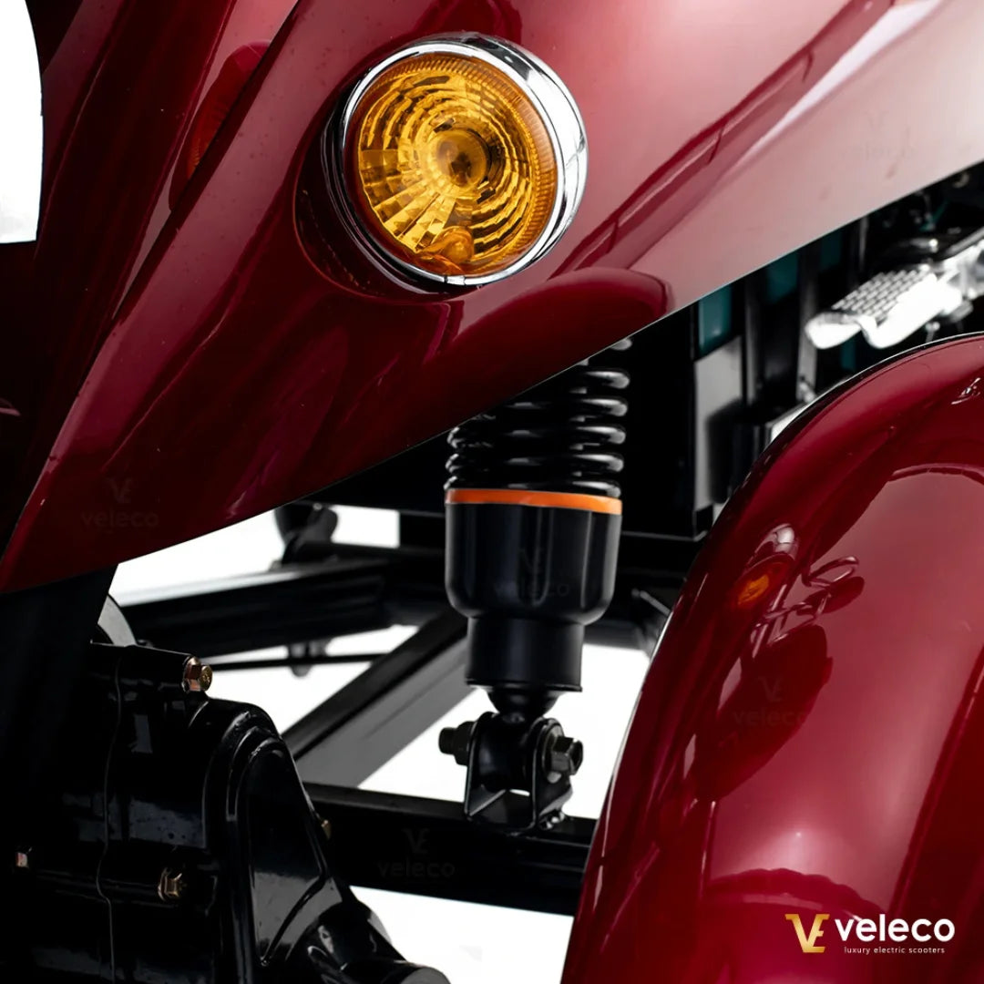 Electric Mobility Scooter Veleco Zt63 features a stylish maroon body, mounted suspension, and illuminating signal light.
