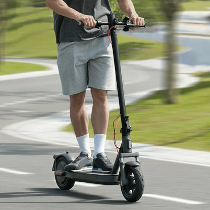 Electric Scooter Xiaomi Elite, sleek black design, rider in casual attire gliding through a park pathway.