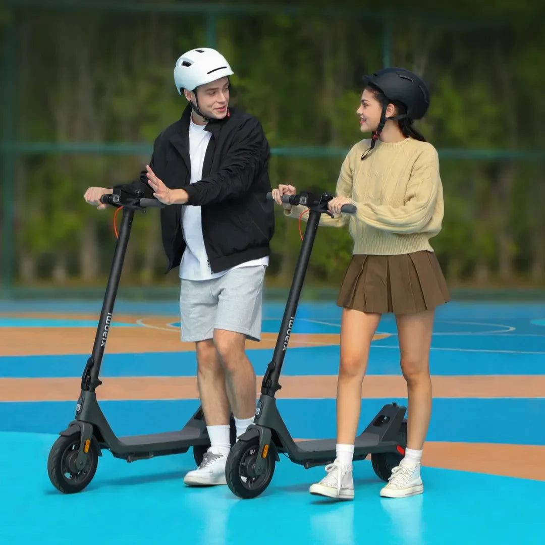 Electric Scooter Xiaomi 4 Lite 2nd Gen, two riders enjoying scooters on a vibrant court, wearing helmets.