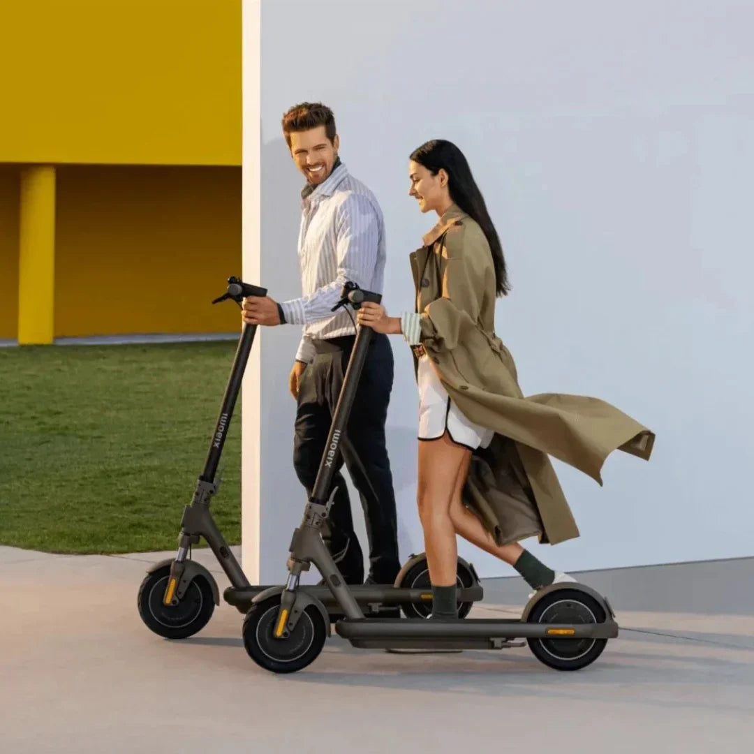 Electric scooter Xiaomi 5 MAX GL – two people with scooters, outdoor setting