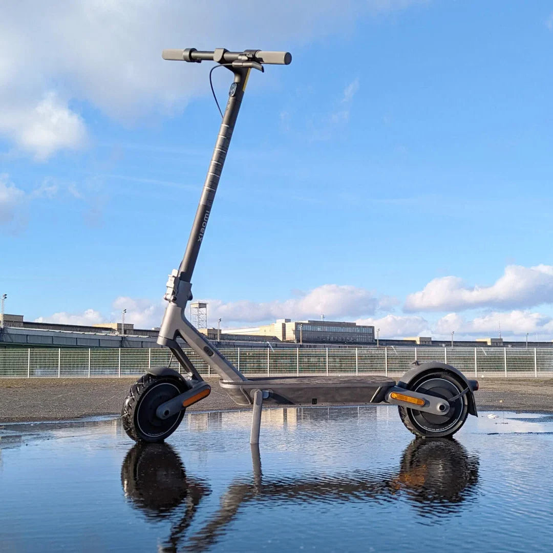 Električni romobil Xiaomi 4 ULTRA – stoji u lokvi, odraz, vani