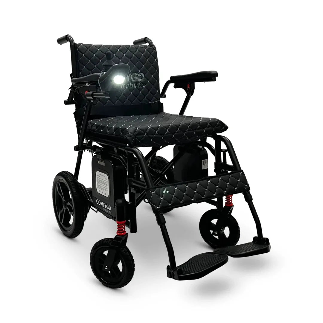 Electric wheelchair ComfyGO X7 – front three-quarter view, unfolded, with black quilted seat and headlamp on